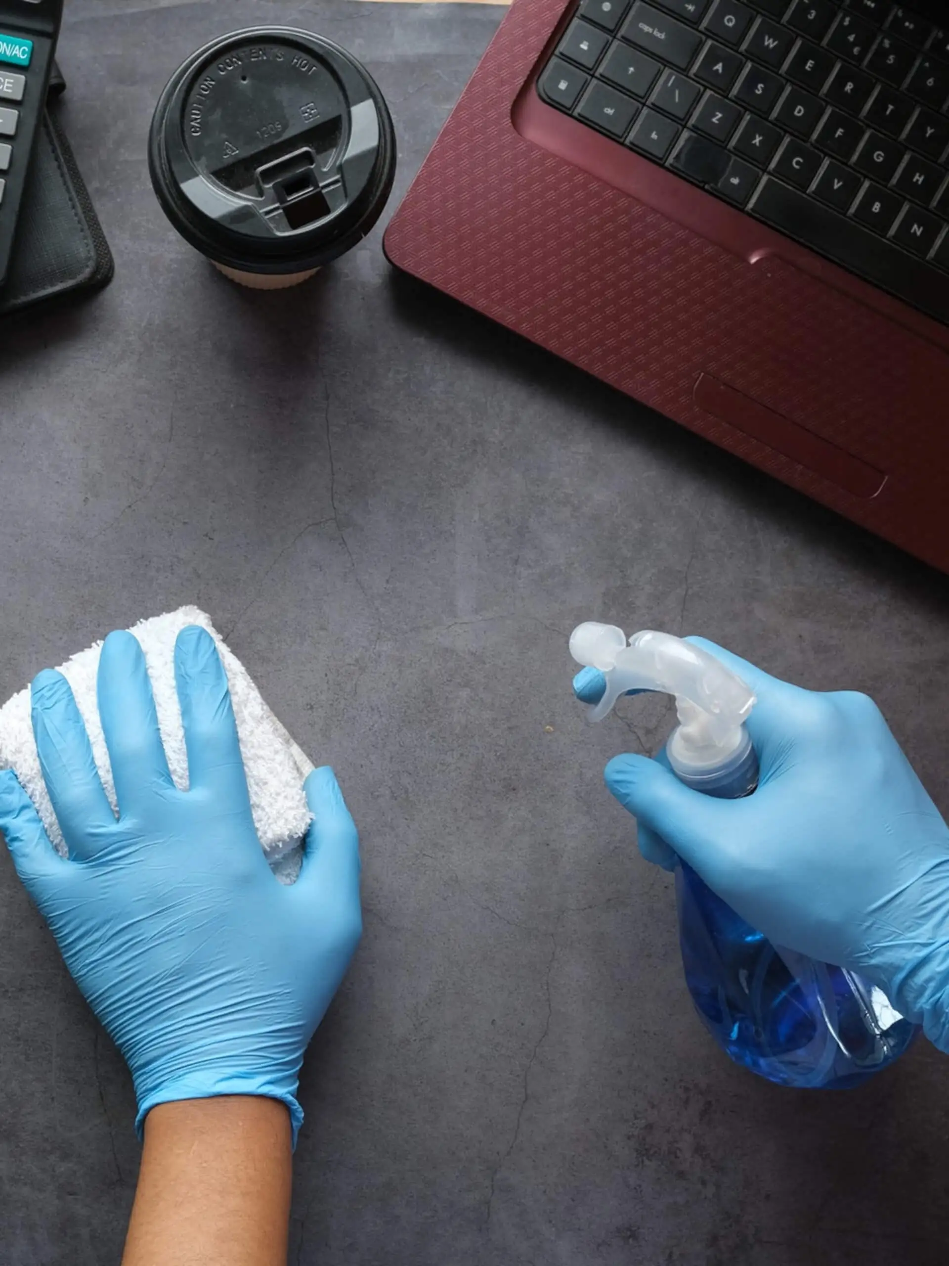 Büroreinigung in Nürnberg – Schreibtisch wird mit Handschuhen gereinigt