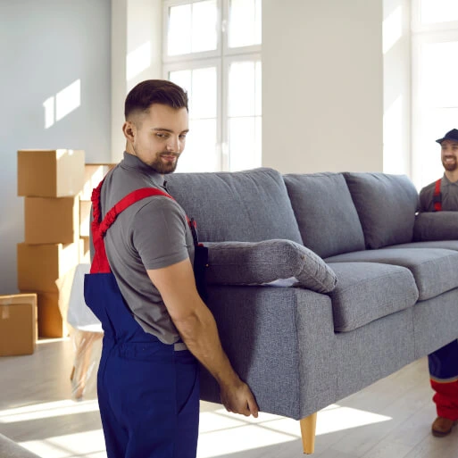 Umzug, Entrümpelung und Haushaltsauflösung in Nürnberg – Mann hebt Sofa, im Hintergrund Kartons